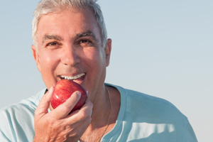 Man with Dentures Eating An Apple